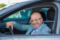 Handsome man smile on face sitting in his car, hands on wheel