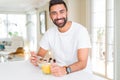 Handsome man smiling eating healthy breakfast and drinking orange juice in the morning Royalty Free Stock Photo