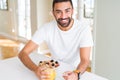 Handsome man smiling eating healthy breakfast and drinking orange juice in the morning Royalty Free Stock Photo