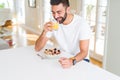 Handsome man smiling eating healthy breakfast and drinking orange juice in the morning Royalty Free Stock Photo