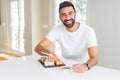 Handsome man smiling happy enjoying eating fresh colorful asian sushi using chopsticks Royalty Free Stock Photo