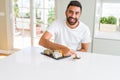 Handsome man smiling happy enjoying eating fresh colorful asian sushi using chopsticks Royalty Free Stock Photo