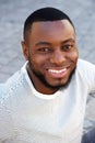 Handsome man smiling sitting outside in striped shirt Royalty Free Stock Photo