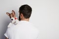 Handsome man snuggling and hugging his basenji puppy dog, close friendship against a white background. Royalty Free Stock Photo