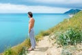 Handsome man standing on hill and looking on sea. Side view. Royalty Free Stock Photo