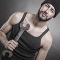 Handsome man standing and holding a wrench Royalty Free Stock Photo