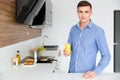 Handsome man standing on the kitchen and drinking juice Royalty Free Stock Photo