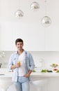 Handsome man standing on the kitchen and drinking orange juice Royalty Free Stock Photo