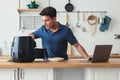 Handsome man standing at kitchen table and cooking toast bread healthy with recipe by Air Fryer machine, using laptop computer Royalty Free Stock Photo