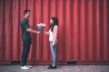 Handsome man standing opposite young woman and giving her flowers Royalty Free Stock Photo