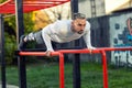 Handsome man street pushup workout on parallel bars, outdoors workout Royalty Free Stock Photo