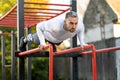 Handsome man street pushup workout on parallel bars, outdoors workout Royalty Free Stock Photo