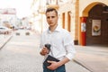 Handsome man in a stylish shirt with coffee and a notebook near