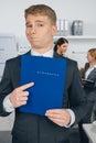 Handsome man in suit holding folder with inscription in german Royalty Free Stock Photo