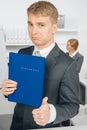 Handsome man in suit holding folder with inscription in german Royalty Free Stock Photo