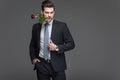 handsome man in suit holding red rose in mouth, Royalty Free Stock Photo