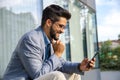 Handsome man in suit sitting in front of office building Royalty Free Stock Photo