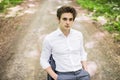 Handsome man in suit sitting on office chair on road in green forest. Business concept Royalty Free Stock Photo