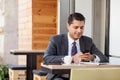 Handsome man with suit is using telephone in cafe Royalty Free Stock Photo