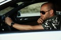 Handsome man in sunglasses posing in car Royalty Free Stock Photo