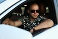 Handsome man in sunglasses posing in car Royalty Free Stock Photo