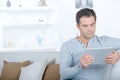 Handsome man surfing on tablet on couch Royalty Free Stock Photo
