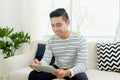 Handsome man surfing on tablet on a couch at home Royalty Free Stock Photo