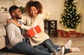 Handsome man surprising girl with Christmas present