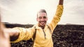 Handsome man taking a selfie climbing a rock. Smiling hiker taking a portrait with action cam hiking a mountain