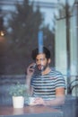 Handsome man talking on cellphone at cafe Royalty Free Stock Photo