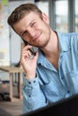 Handsome man is talking on phone and smiling. Operator takes phone call. Royalty Free Stock Photo