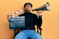 Handsome man with tattoos holding video film clapboard and louder looking at the camera blowing a kiss being lovely and sexy