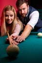 handsome man teaching his girlfriend to play snooker Royalty Free Stock Photo