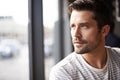 Handsome man, thinking and vision by window at cafe for ambition, travel or sightseeing. Face of male person waiting in Royalty Free Stock Photo