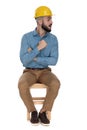 Handsome man threatening with fist while sitting with arms folded Royalty Free Stock Photo