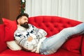 Handsome man tired while preparation christmas gifts. Christmas holidays. Young father sleeping at modern sofa in living room