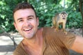 Handsome man with titi monkey on his shoulder