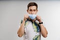 Handsome man touches medical mask in quarantine covid-19 period. Man weared t-shirt isolated white background Royalty Free Stock Photo