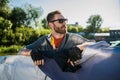 Handsome man traveling by yacht. Casual outfit, man dressed in grey hoodie, spring time, bearded man in sunglasses on