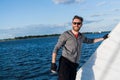 Handsome man traveling by yacht. Casual outfit, man dressed in grey hoodie, spring time, bearded man in sunglasses on