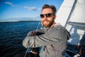 Handsome man traveling by yacht. Casual outfit, man dressed in grey hoodie, spring time, bearded man in sunglasses on