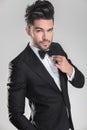 Handsome man in tuxedo ajusting his bow tie Royalty Free Stock Photo