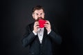 handsome man in tuxedo biting or eating love heart for valentines day, heartbreaker