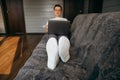 Man is using a laptop while lying on sofa in living room Royalty Free Stock Photo