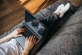 Man is using a laptop while lying on sofa in living room Royalty Free Stock Photo