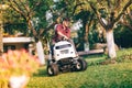 handsome man using lawn mower and cutting grass in home, residential garden Royalty Free Stock Photo