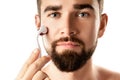 Handsome man using meso roller for better beard growth