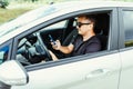 Handsome Young Man using mobile phone while driving a car Royalty Free Stock Photo