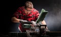 Handsome man using modern electric circular saw in the workshop