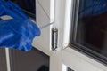 Handsome man using a screwdriver to install a window handle and looking at the camera. Making a house cozy and warm Royalty Free Stock Photo